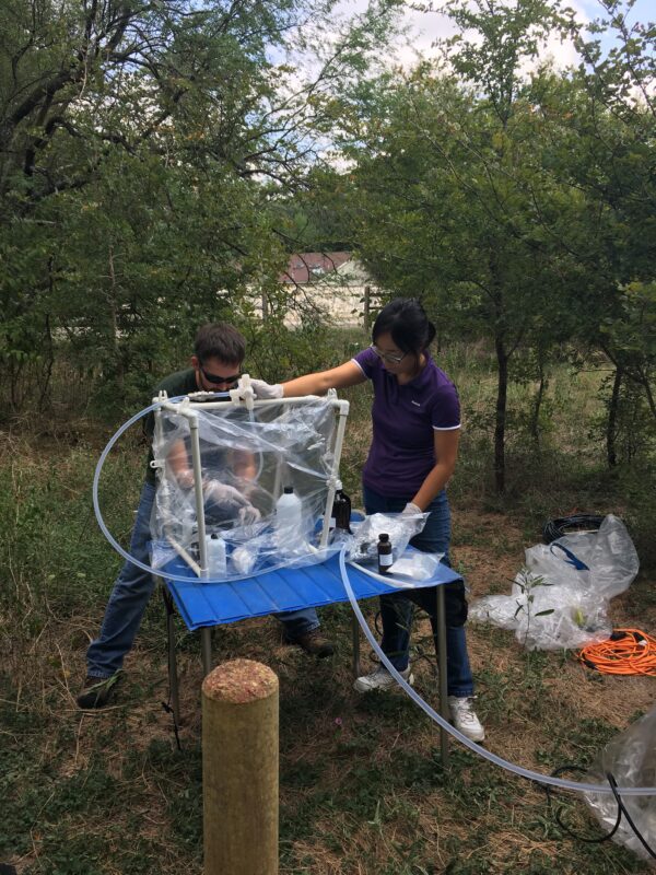Hydrographers pouring water into sampling equipment on a table.
