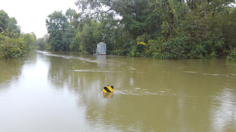 Flooding at the Neches River with a partially submerged gage house in the background