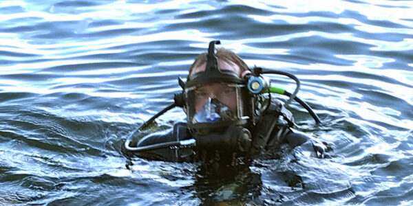 Scuba diver with his head just above the surface of the water